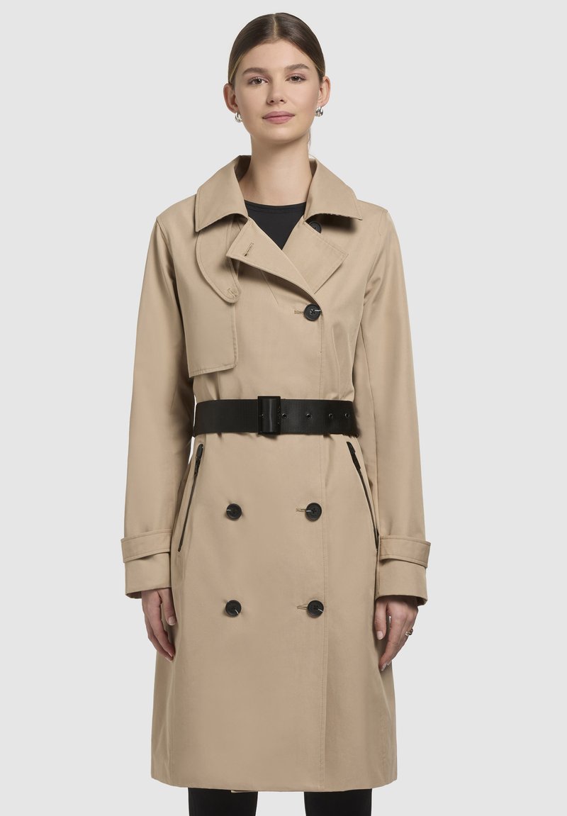 Beige trench coat with double-breasted buttons, wide collar, and set-in belt. Features side pockets and long sleeves with buttoned cuffs.