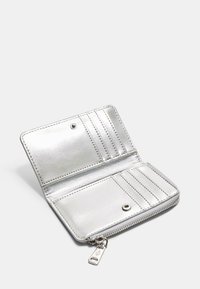 Sølv pung med metallisk finish, lynlås lukning, flere kortrum og trykknap. Indvendigt har den en glat tekstur og minimalistisk syning.
