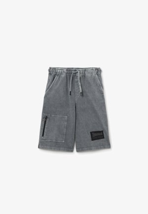 Gray denim shorts with an elastic waistband, adjustable drawstring, a side zipper pocket, and a black logo patch on the lower leg.