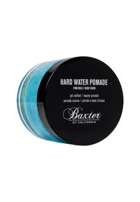 Rund burk med blå pomad med ett glänsande svart lock, märkt "Hard Water Pomade" med vit text, som indikerar fast håll och hög glans.