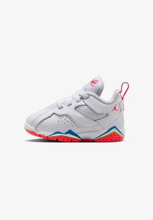 Baskets blanches de sport avec des accents rouges, bleus et jaunes, panneau latéral en mesh, lacets et logo Jumpman rouge au talon et à la languette.