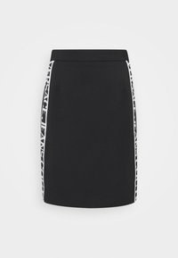 Svart minikjol med vertikala vita logodetaljer längs sidorna. Har en slank design och en strukturerad midjerem, tillverkad av mjukt material.