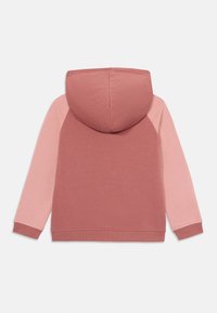 Φούτερ με κουκούλα σε ροζ-κόκκινη απόχρωση για το σώμα και ανοιχτό ροζ μανίκια. Κατασκευασμένο από μαλακό ύφασμα με ριγέ μανσέτες και στρίφωμα.