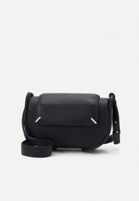 Črna usnjena torbica čez ramo z zaponko na preklop, srebrnimi poudarki in nastavljivim naramnim trakom, postavljena na belem ozadju.