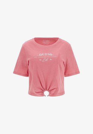 Pink kortærmet cropped t-shirt lavet af bomuld, med en cirkulær ringdetalje ved kanten og hvid tekstbranding på forsiden.