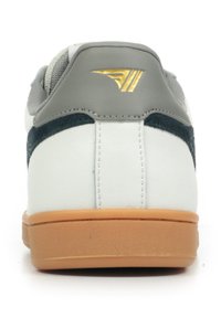 Sneaker bianco in pelle con dettagli in suede grigio, suola in gomma beige e logo dorato sul tallone. Design flat e low-top.