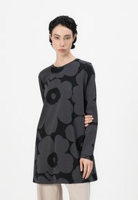 Long-sleeved tunic made of soft fabric, featuring a black background with large gray floral patterns and a round neckline.