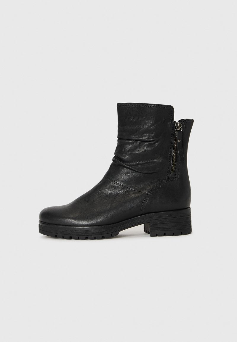 Bottine en cuir noir avec fermeture éclair latérale, petit talon bloc, bout rond et détail supérieur légèrement froncé.