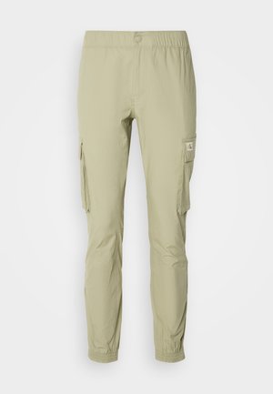 Pantaloni cargo verde chiaro con vita elastica, tasche laterali e una vestibilità leggermente affusolata. Realizzati in un tessuto leggero.