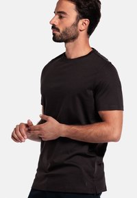 Zwart T-shirt met korte mouwen, gemaakt van katoen, met een ronde hals en een relaxte pasvorm met subtiele stikdetails.