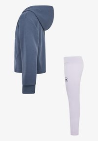 Hettegenser i mørk blåt stoff med lange ermer, sammen med hvite leggings med logo detalj nær ankelen.