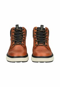 Bottines en cuir marron avec des accents noirs, bout rond, lacets noirs, et semelle intercalaire crème contrastante.