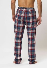 Geruite pyjamabroek met rode, blauwe en witte patronen, elastische tailleband met "POLO ASSN." logo, katoenen stof, loose fit, zijzakken.
