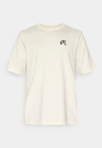 Κρεμ T-shirt από βαμβάκι, με κοντά μανίκια και στρογγυλή λαιμόκοψη. Περιλαμβάνει ένα μικρό μαύρο κεντητό σχέδιο στο στήθος.