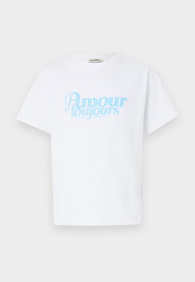 White cotton t-shirt featuring light blue text reading "Amour toujours in Paris Summer 25." Short sleeves and a relaxed fit.