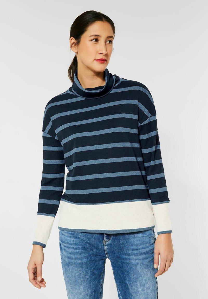Marineblau und hellblau gestreiftes Langarmoberteil mit einem Schalkragen, aus weichem Stoff gefertigt. Es hat einen kontrastierenden, hellcremefarbigen unteren Saum.