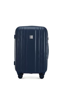 Marineblauwe harde koffer met gestructureerde oppervlakte, verticale ribbels, een logo plaat, een uitschuifbare handgreep en vier spinnerwielen voor mobiliteit.