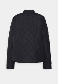 Černá prošívaná bunda z pohledu zezadu, se zaobleným límcem a šikmým prošíváním. Jednoduché bílé pozadí.