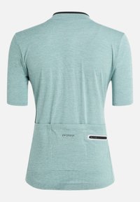 Chemise à manches courtes bleu clair en tissu texturé, avec un col noir et une poche arrière dotée d'une fermeture éclair blanche. Logo dans le bas du dos.