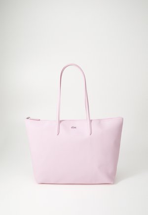 Rózsaszín vászontáska texturált anyagból, két hosszú pánttal és felső cipzáras záródással. A márkainterjú a táska elején található.