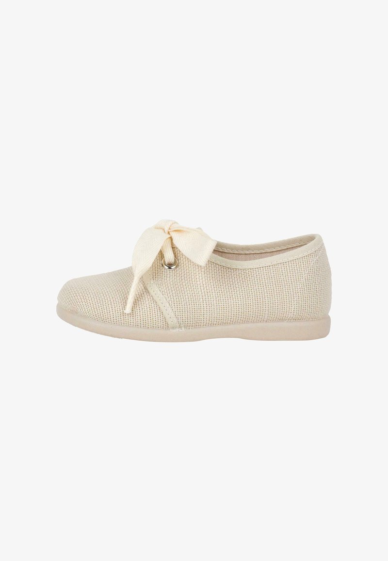 Beige knit shoe with a rounded toe and a textured upper. Features a decorative bow at the front and a smooth rubber sole.