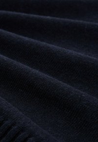 Dunkelblauem Stoff mit einer weichen, strukturierten Oberfläche, die parallele Falten aufweist und ein feines Gewebe sowie eine gleichmäßige Farbe zeigt.