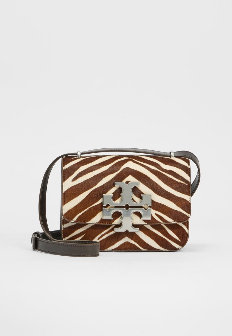 Brązowa torebka skórzana w paski zebry w kolorze kremowym, z srebrnym logo, wyposażona w zapięcie na klapkę i odczepiany brązowy pasek.