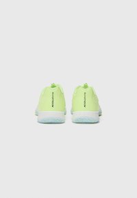 Neon yellow athletic shoes with a textured surface, featuring white soles and a brand logo on the heel, designed for comfort and support.