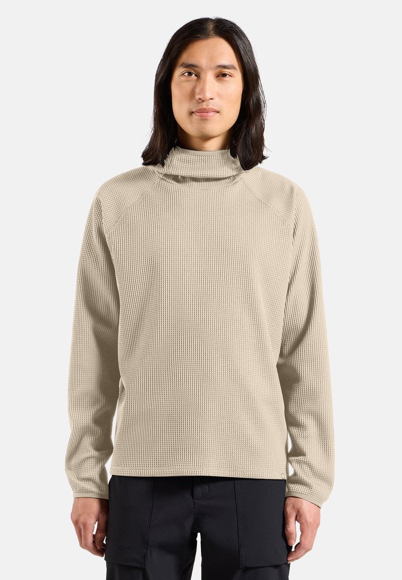 Beige strukturierter Sweatshirt mit hohem Kragen, langen Ärmeln und lockerem Schnitt. Mit geripptem Material und Raglanärmeln.