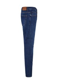 Jean en denim bleu foncé vu de côté avec une poche arrière et un patch en cuir marron de la marque sur la ceinture.