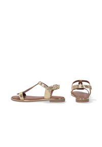 Goldene flache Sandalen mit strukturiertem Obermaterial und verstellbaren Knöchelriemen. Mit einer glatten braunen Innensohle und einer flachen Gummisohle.