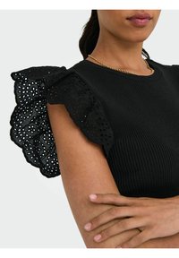 Sort ribbet top med kontrasterende blonderuflede ærmer, der har rund halsudskæring og tætsiddende pasform. Glat tekstur med blomsterudskæringer på ærmerne.