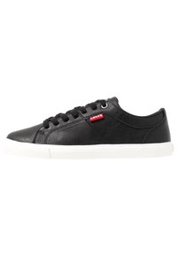 Sneaker in pelle nera con suola in gomma bianca, punta tonda e lacci piatti. Presenta un piccolo logo rosso Levi's sul lato.