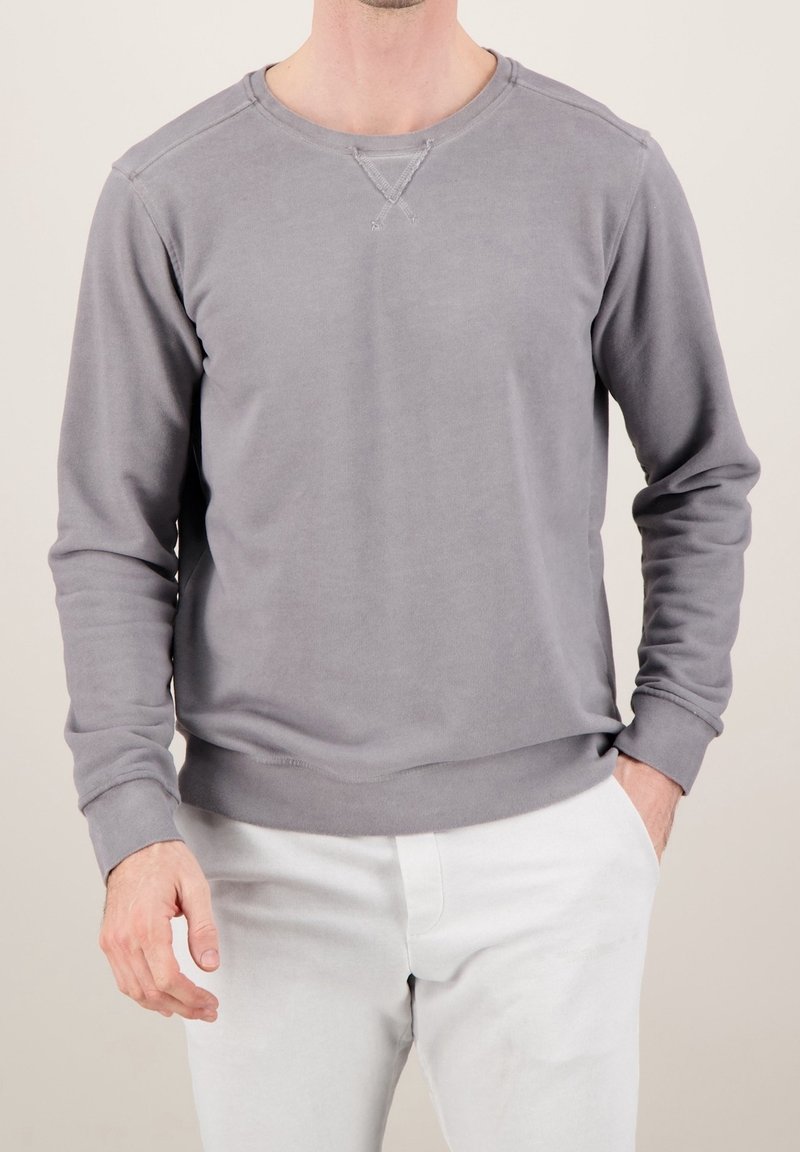 Maglione grigio con maniche lunghe, polsini e orlo a coste, texture morbida e collo a girocollo. Presenta un sottile dettaglio di cucitura a X sul collo.