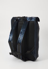 Dark navy backpack with padded mesh back and adjustable straps, positioned against a plain white background.
