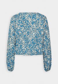 Blusa cropped a maniche lunghe con motivo astratto blu e bianco. Il tessuto ha una consistenza liscia con maniche gatherate ai polsi.