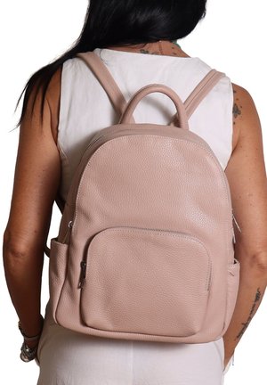 Sac à dos en cuir rose avec une texture gaufrée, forme arrondie, doubles bretelles, poche zippée à l'avant et poche latérale.