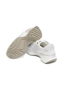 Scarpe sportive bianche con upper testurizzato, lacci prominenti e suola in gomma con un modello di battistrada ondulato.