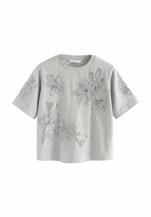 Haut gris clair à manches courtes avec col rond et détails subtils de broderie florale sur le devant et les manches.