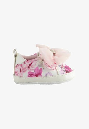 White floral-patterned toddler shoes with a large pink bow on the front, featuring a back pull tab and a soft rubber sole.