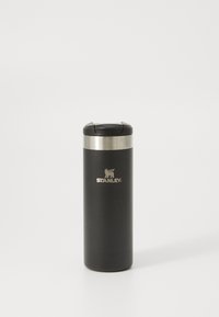 Gobelet de voyage en acier inoxydable avec une finition noir mat, bande en métal argenté et couvercle noir. Présente un logo en relief à l'avant.