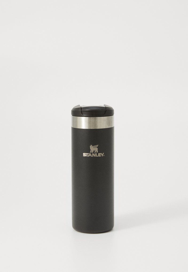 Gobelet de voyage en acier inoxydable avec une finition noir mat, bande en métal argenté et couvercle noir. Présente un logo en relief à l'avant.