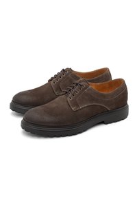 Scarpe derby in suede marrone con punta rotonda, suola in gomma bassa e lacci sulla parte anteriore con occhielli metallici. Texture liscia e morbida.