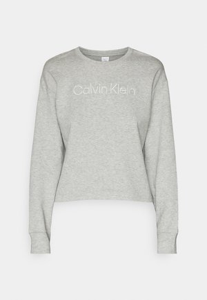 Sweatshirt scurt gri, realizat dintr-un material moale. Dispune de mâneci lungi și un guler rotund cu logo-ul "Calvin Klein" în alb.