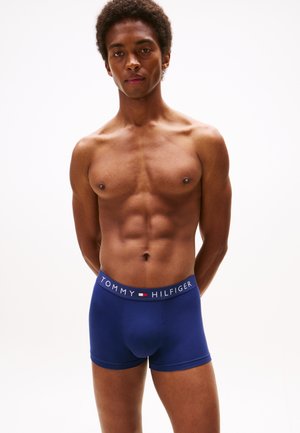 Marinblå boxershorts med TOMMY HILFIGER-logga på midjebandet. Mjuk tyg, figurnära design, medellång klippning och sömlös konstruktion.