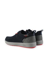 Scarpe in camoscio blu navy con suola in gomma grigia e rossa. Design arrotondato, cuciture a contrasto e anelli in tessuto sul tallone per una facile calzata.