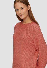 Rosa Strickpullover mit Rundhalsausschnitt, strukturiertem Stoff, überschnittenen Schultern und einer lockeren Passform.