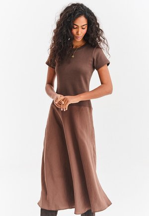 Brązowa sukienka wykonana z miękkiej tkaniny, z okrągłym dekoltem, krótkimi rękawami i luźną sylwetką sięgającą do połowy łydki.