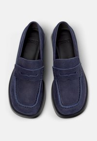 Μπλε ναυτικό μοκασίνια από σουέτ με τετράγωνη μύτη, διακοσμητική ραφή και ανάγλυφη ραφή στο πάνω μέρος. Μαύρη λαστιχένια σόλα.