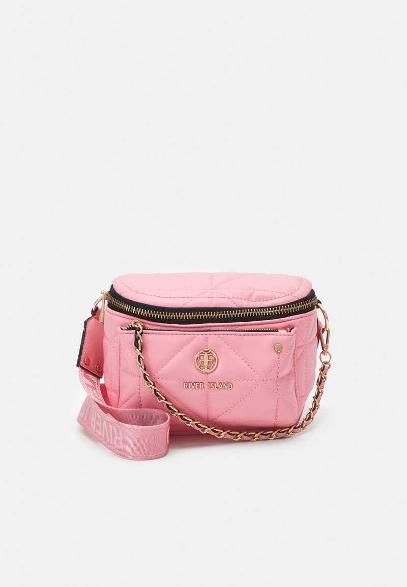 Pink quilted crossbody bag with gold hardware, featuring a zip closure, branded accent, and detachable strap with logo.